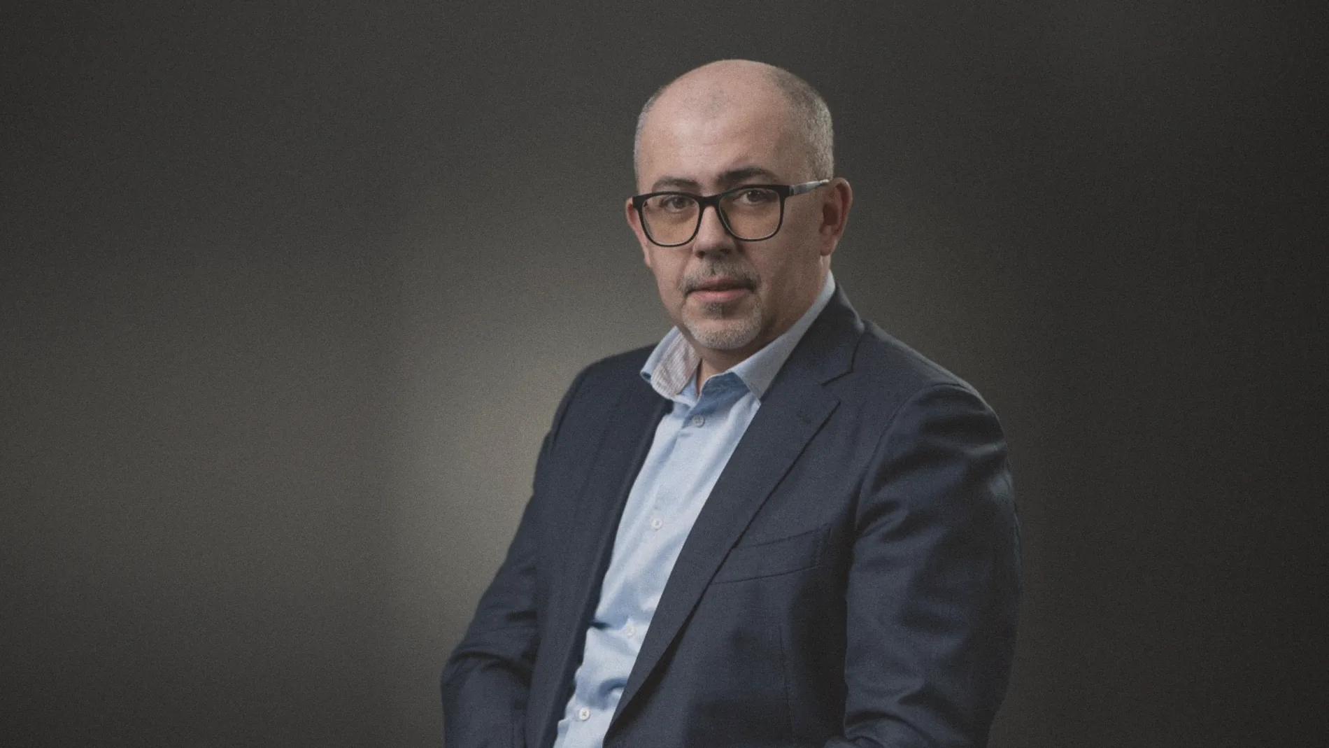 Portrait of lawyer Cătălin Chituc in a suit, against a dark grey background